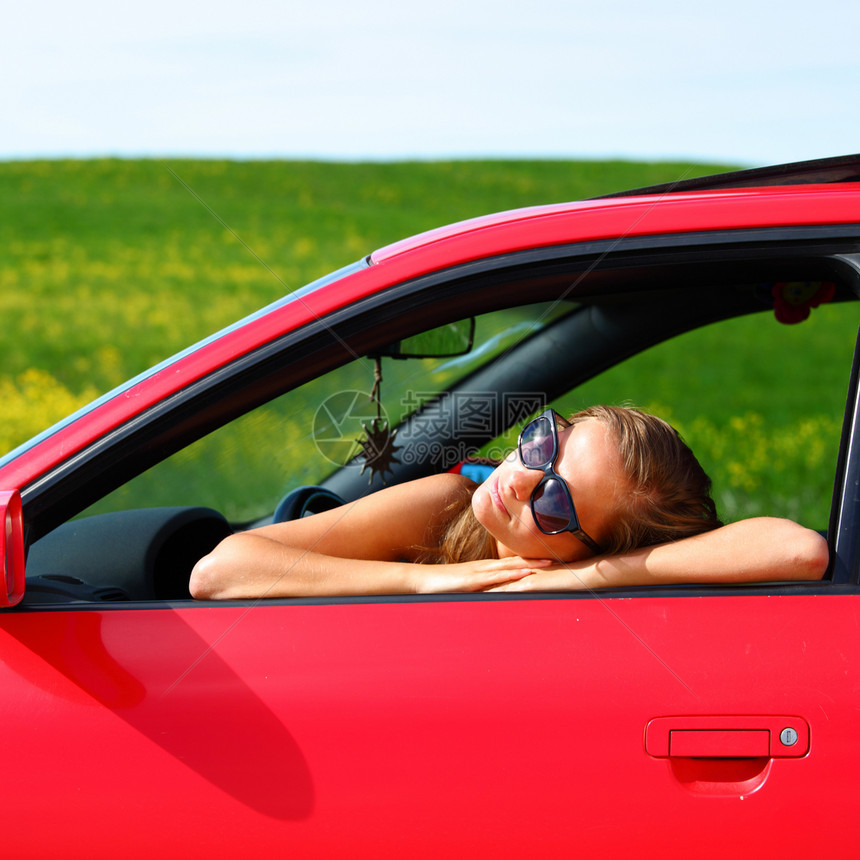 妇女乘坐红色车快乐女性头发波浪太阳镜旅行奢华钥匙金发成人图片