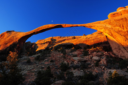 景观拱形砂岩侵蚀公园蓝色天空日出辉光黄色阳光岩石背景图片