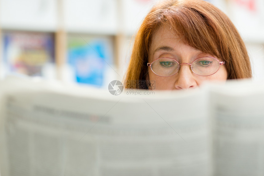 图书馆里戴眼镜阅读报纸的老年妇女退休奶奶读者中年女士女性祖母养老金眼镜娱乐图片