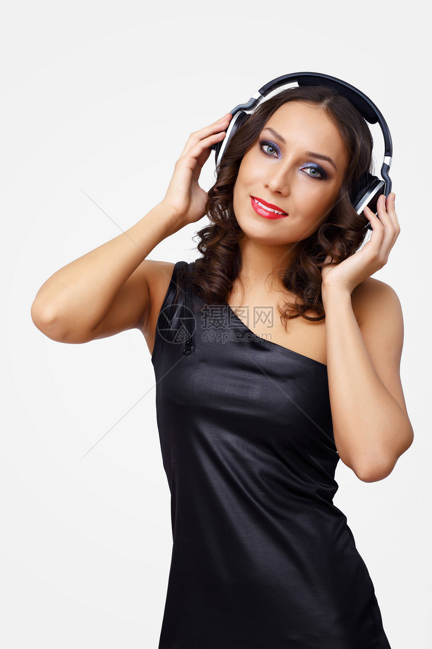 青年妇女戴耳机的肖像成人工作室音乐女士噪音微笑快乐娱乐头发幸福图片