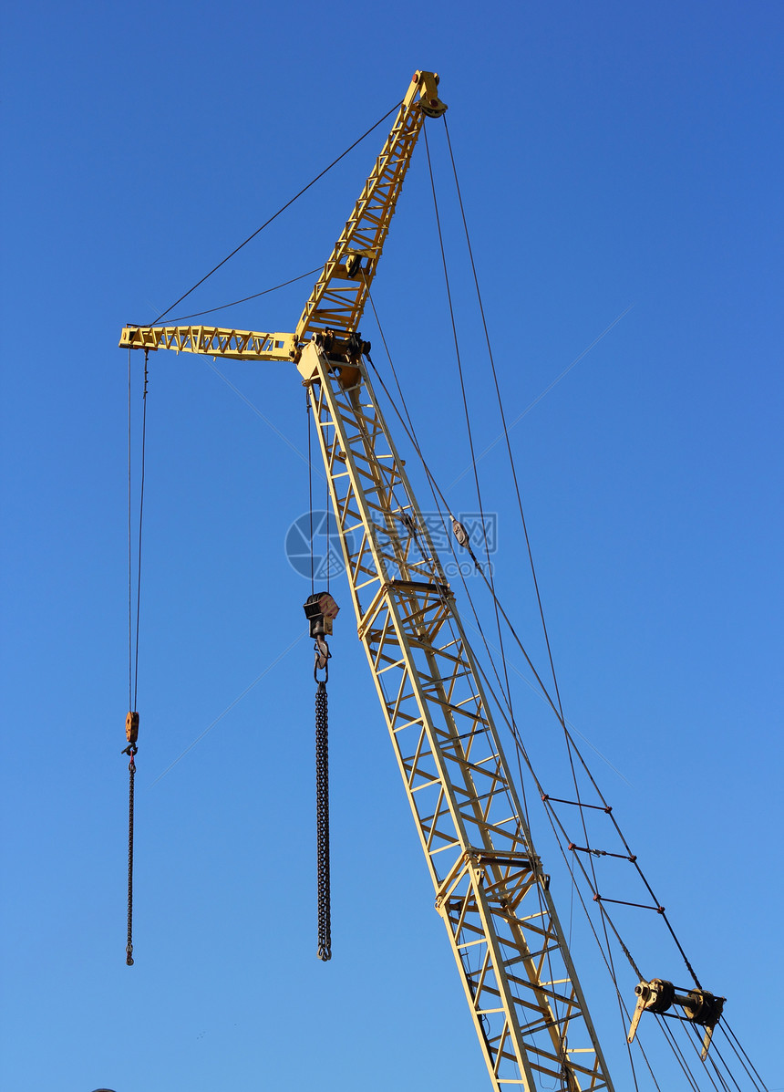 建筑工地上的黄黄色起重机和蓝色天空黄色商业建筑学住房机械项目金属生长工程起重机图片