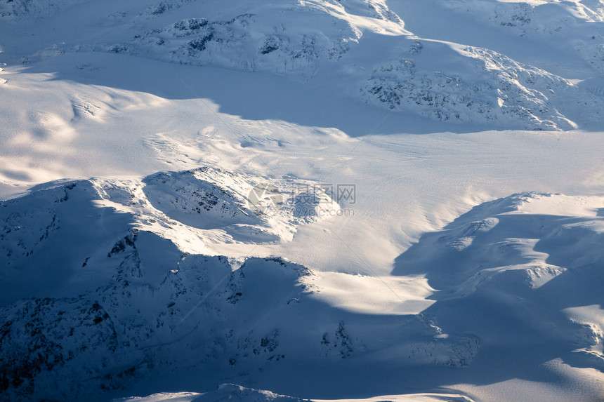 加拿大不列颠哥伦比亚BC积雪峰的空中观察太阳寂寞山脉蓝色阳光山峰假期荒野旅游滑雪图片