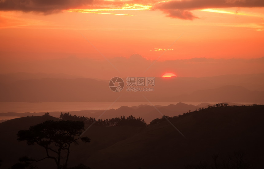 美丽的日落丘陵橙子天空地平线山脉树木场景丛林太阳荒野图片