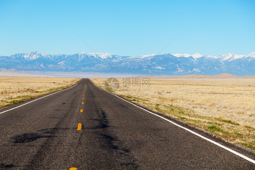 空高速公路驶近山地山脉乡村黄色车道寂寞旅行沙漠地平线城市蓝色土地图片