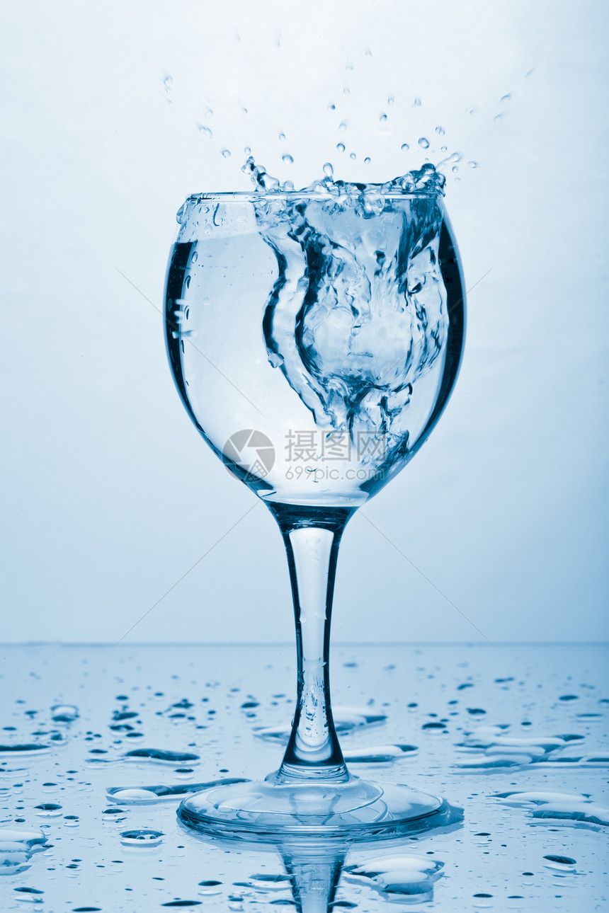 纯洁的泉水喷入玻璃杯中气泡酒精调子蓝色涟漪溪流饮料运动波纹飞溅图片