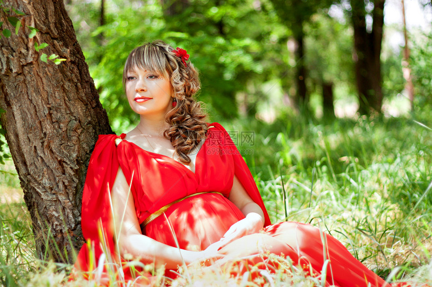 坐在草地上的孕妇森林红色女性腹部成人喜悦图片