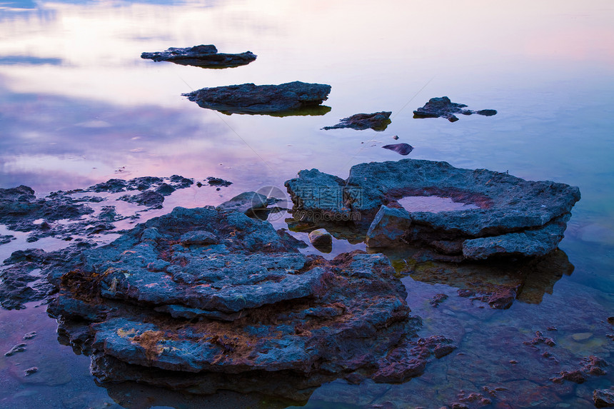 日落时在海中的石头图片