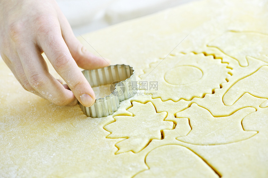 将饼干从面团中切开手工金属手指面包食物烘烤面粉刀具烹饪款待图片