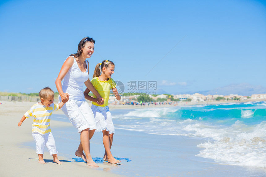 热带海滩上幸福家庭享受海浪海洋妈妈父母假期乐趣女孩女儿母亲图片