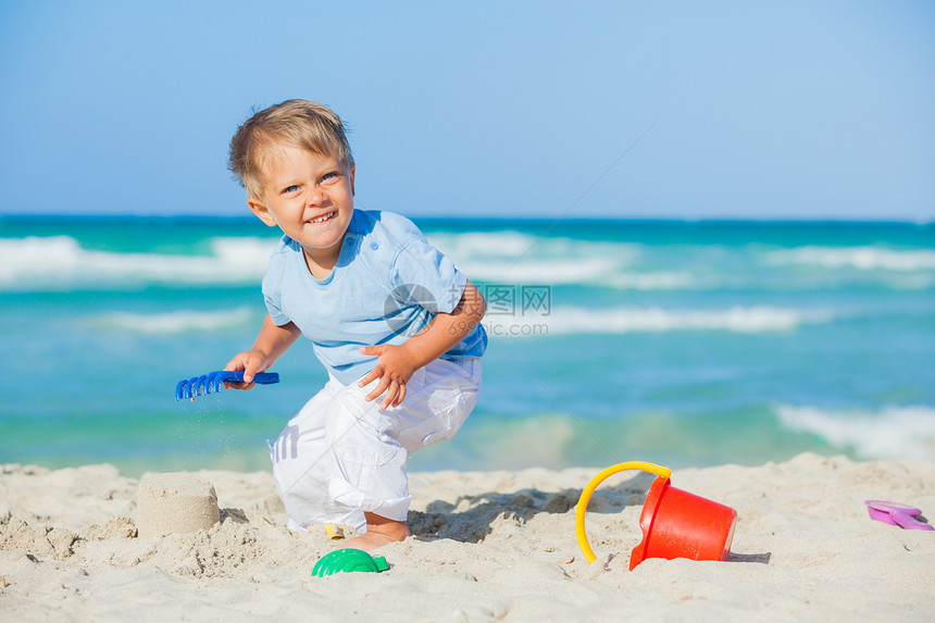 海滩上玩玩具的男孩旅行海岸假期天堂儿童热带男生支撑孩子异国图片