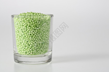 玻璃杯中的斯塔克小吃绿色调味品粉色染色宏观化合物珍珠圆形白色背景图片