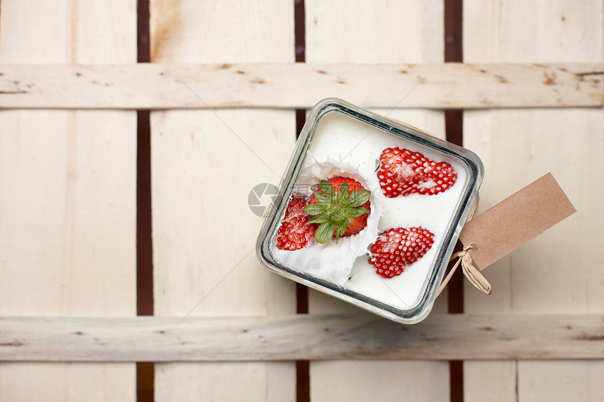 草莓落到牛奶容器中;图片