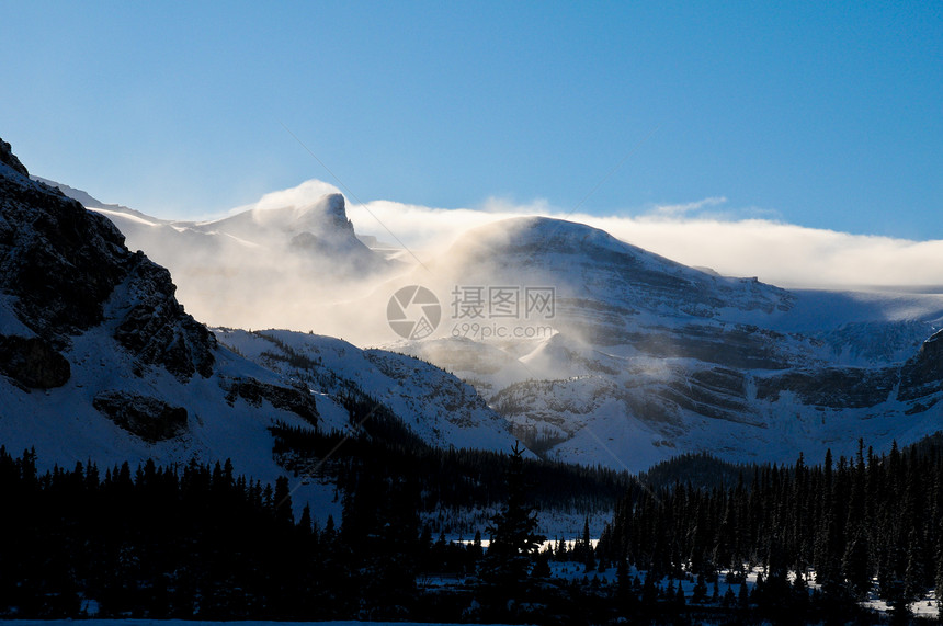 阳光照耀的冬季风景环境公园太阳森林天空全景冻结降雪爬坡岩石图片
