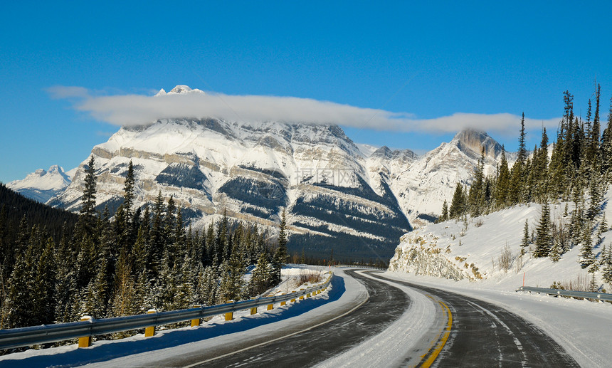 温冬高速公路穿过山峰太阳天空木头交通爬坡岩石冻结蓝色森林顶峰图片