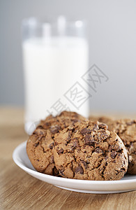 饼干和牛奶盘子小吃巧克力片食物巧克力玻璃桌子背景图片