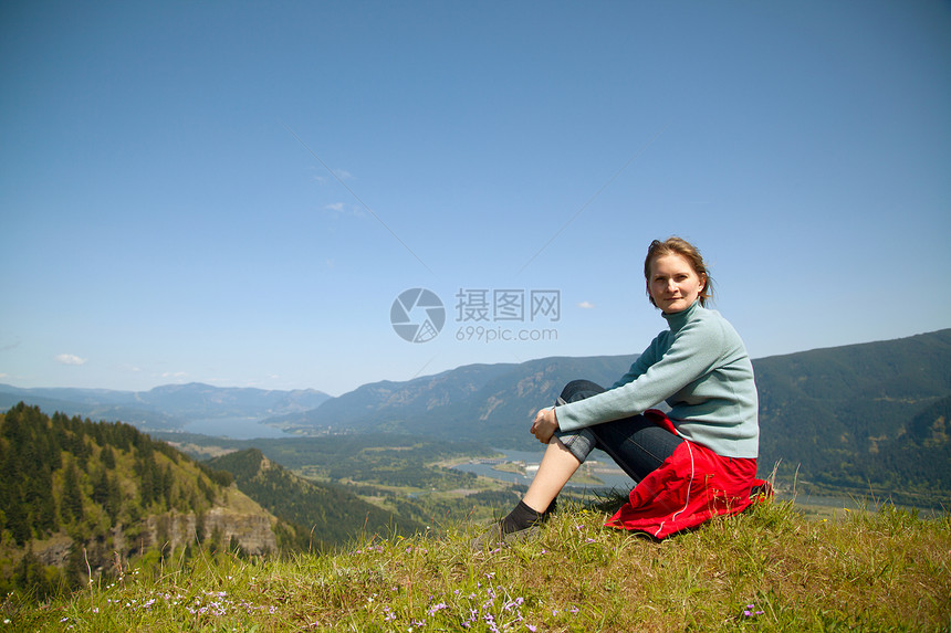 女人坐在悬崖顶闲暇幸福风景微笑顶峰成就远足天空阳光旅行图片