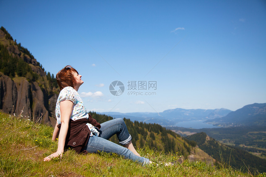 女人坐在悬崖顶远足地平线微笑风景岩石顶峰成就冒险闲暇地形图片