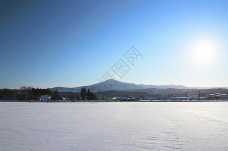 东北雪原毛笔字雪田和山丘白色天空场地旅行日落太阳蓝色阳光雪原背景