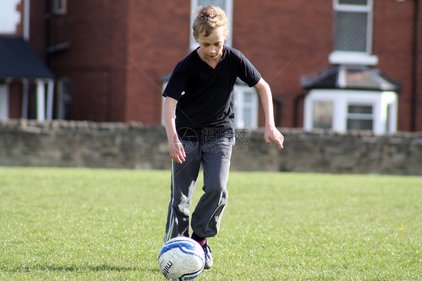 参加足球比赛的少年男孩场地运动竞赛男孩们草地玩家青少年跑步团队植物图片