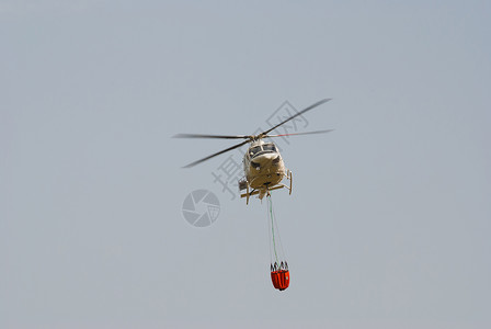 架载水桶的消防员直升机背景图片