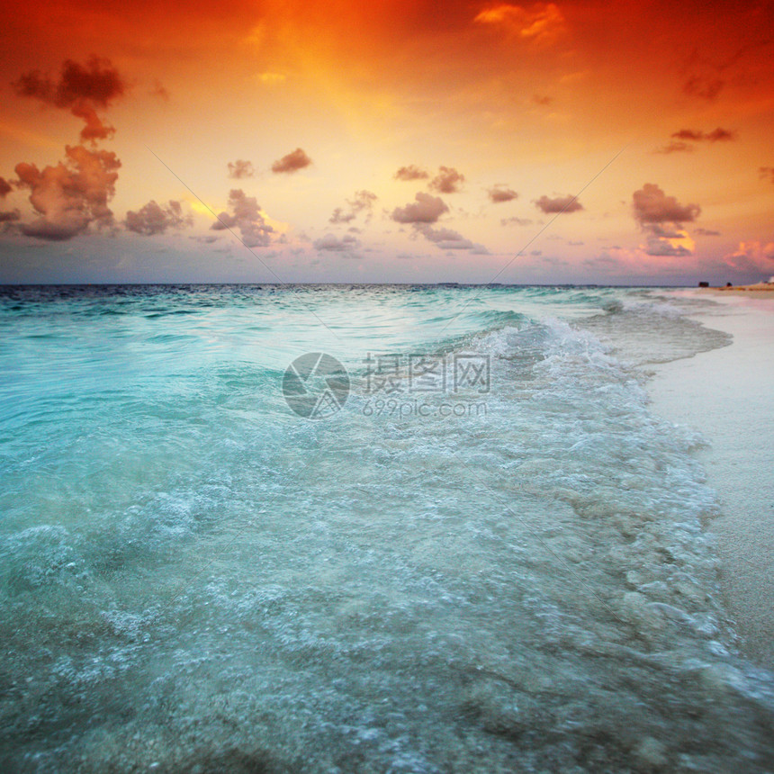 日落在海中地平线天空蓝色橙子晴天太阳季节海滩热带金子图片
