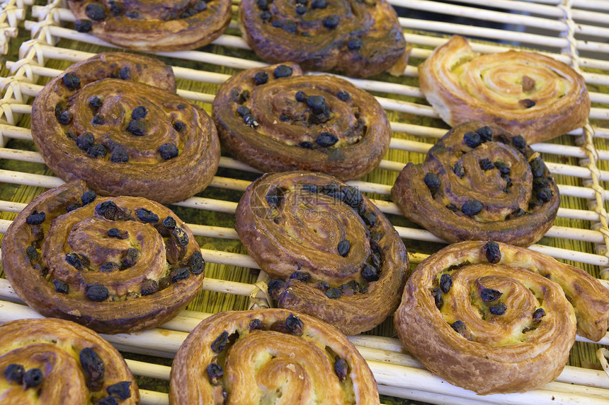 丹麦面粉烹饪团体面包柜台金子皱纹架子葡萄干小吃糕点图片