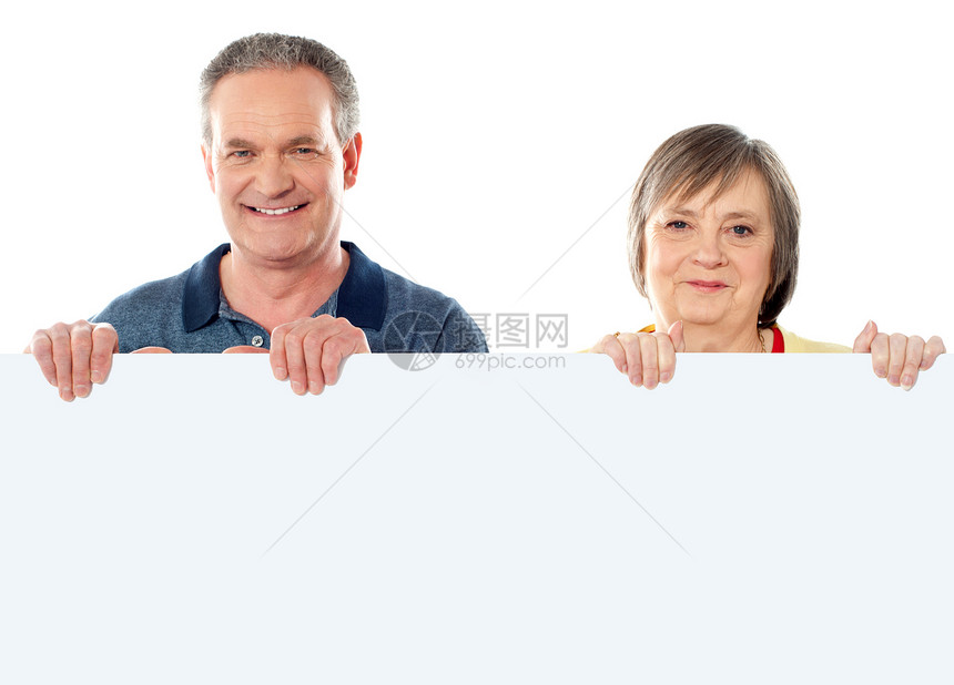持有空白横幅广告的老年夫妇图片