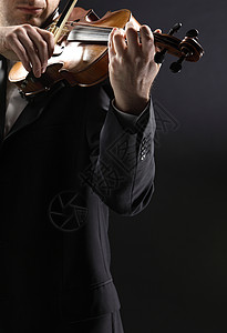 磅礴情绪管弦乐小提琴手 音乐家在黑暗背景下演奏小提琴深色独奏享受男人小提琴家音乐细绳乐器木头玩家背景