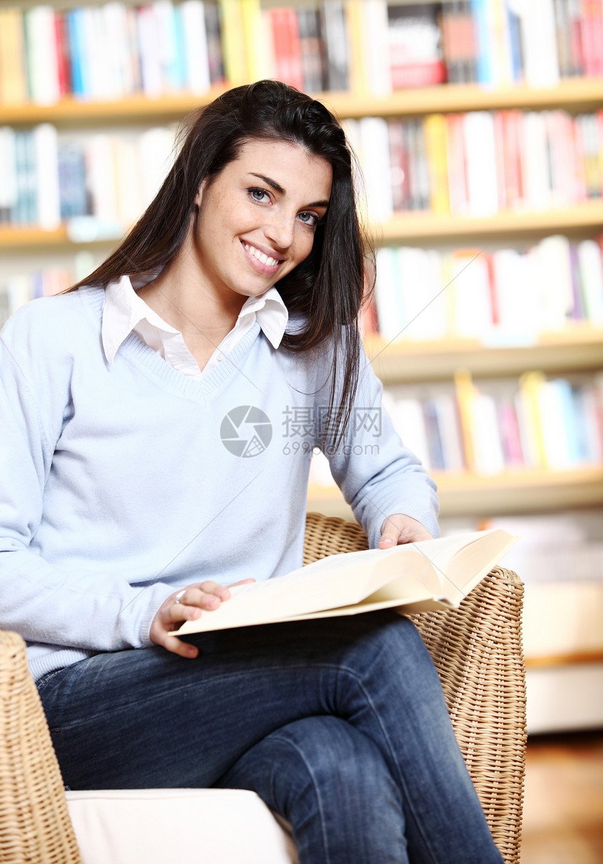 手拿书在书店微笑的女学生  模特女士店铺大学文学学生校园学习书架女孩图书馆图片