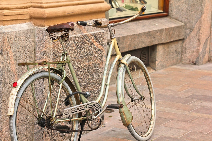 旧自行车留在市中心一栋旧大楼旁边图片
