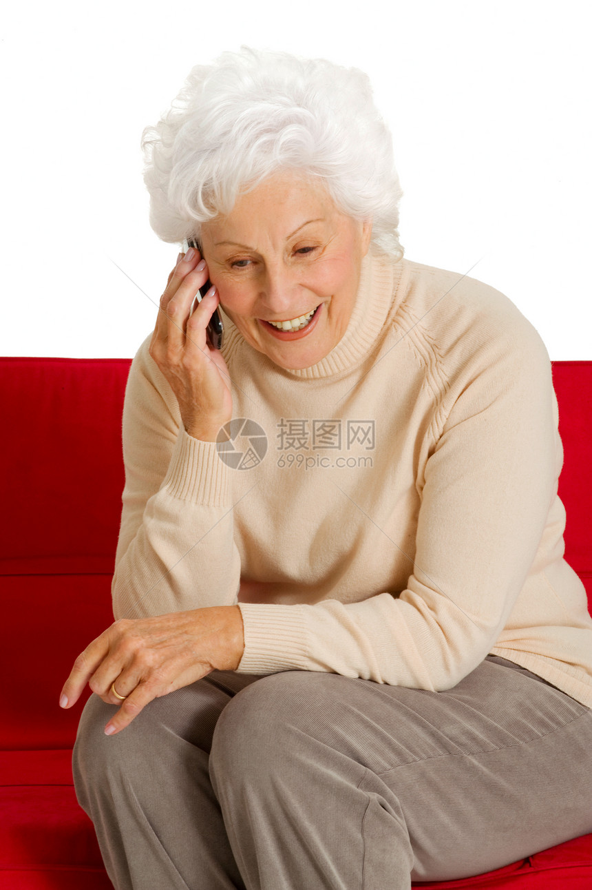 在沙发上带手机的老年妇女红色家庭生活技术通讯白色电话幸福休闲装工具微笑图片