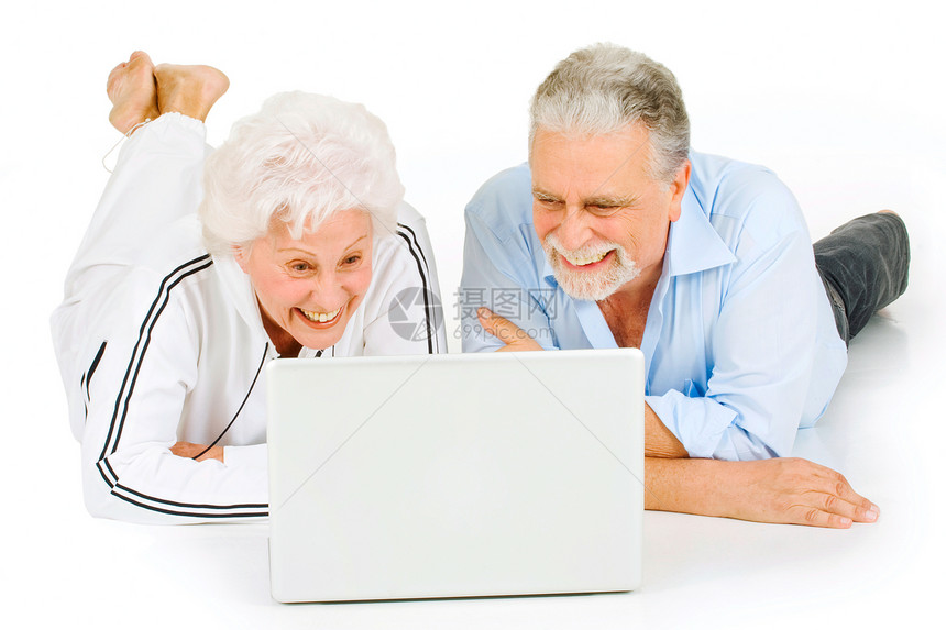 使用膝上型电脑的老年夫妇夫妻网络女士男人微笑工具笔记本胡须通讯说谎图片