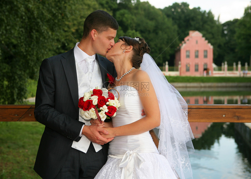 新娘和新郎接吻新婚面纱微笑晴天裙子夫妻套装花束图片