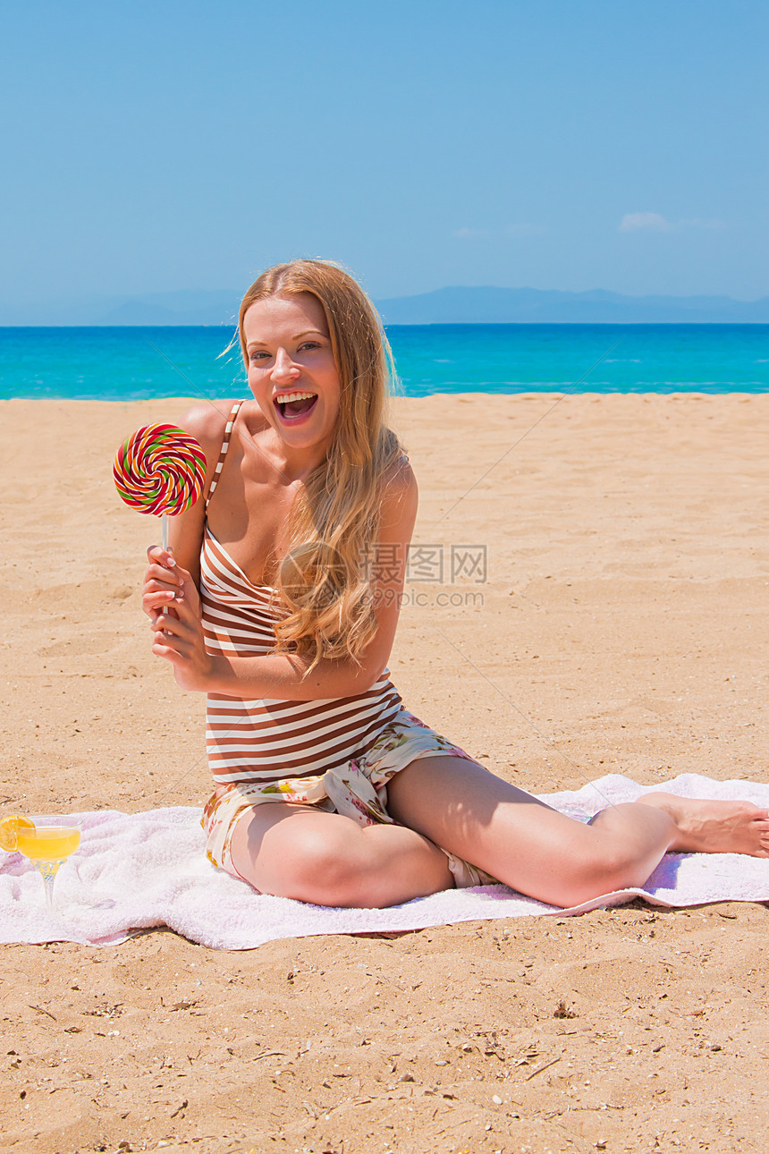 配棒棒棒棒糖的妇女女性气候季节食物糖果假期天空海滩海岸线游泳衣图片