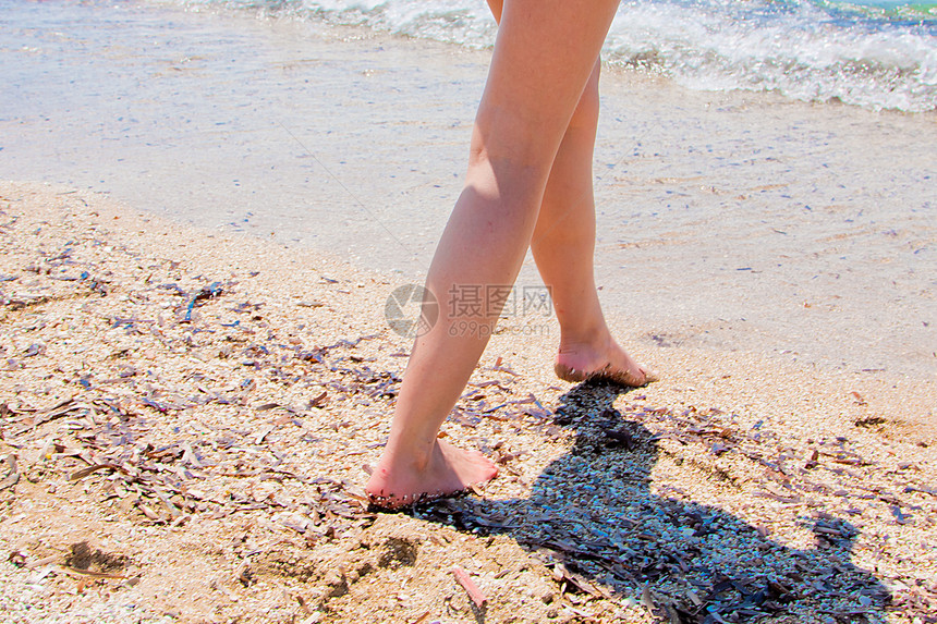 一个女人在海滩上行走人行道旅行风景假期气候乐趣海浪女士时间场景图片