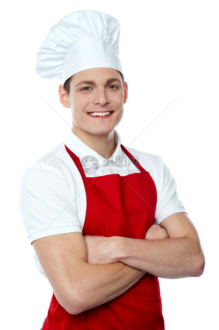 微笑的年轻厨师装着横穿双臂图片