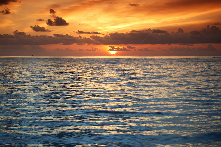 日落在海中假期晴天海洋蓝色地平线天空海岸线反射海浪天气图片