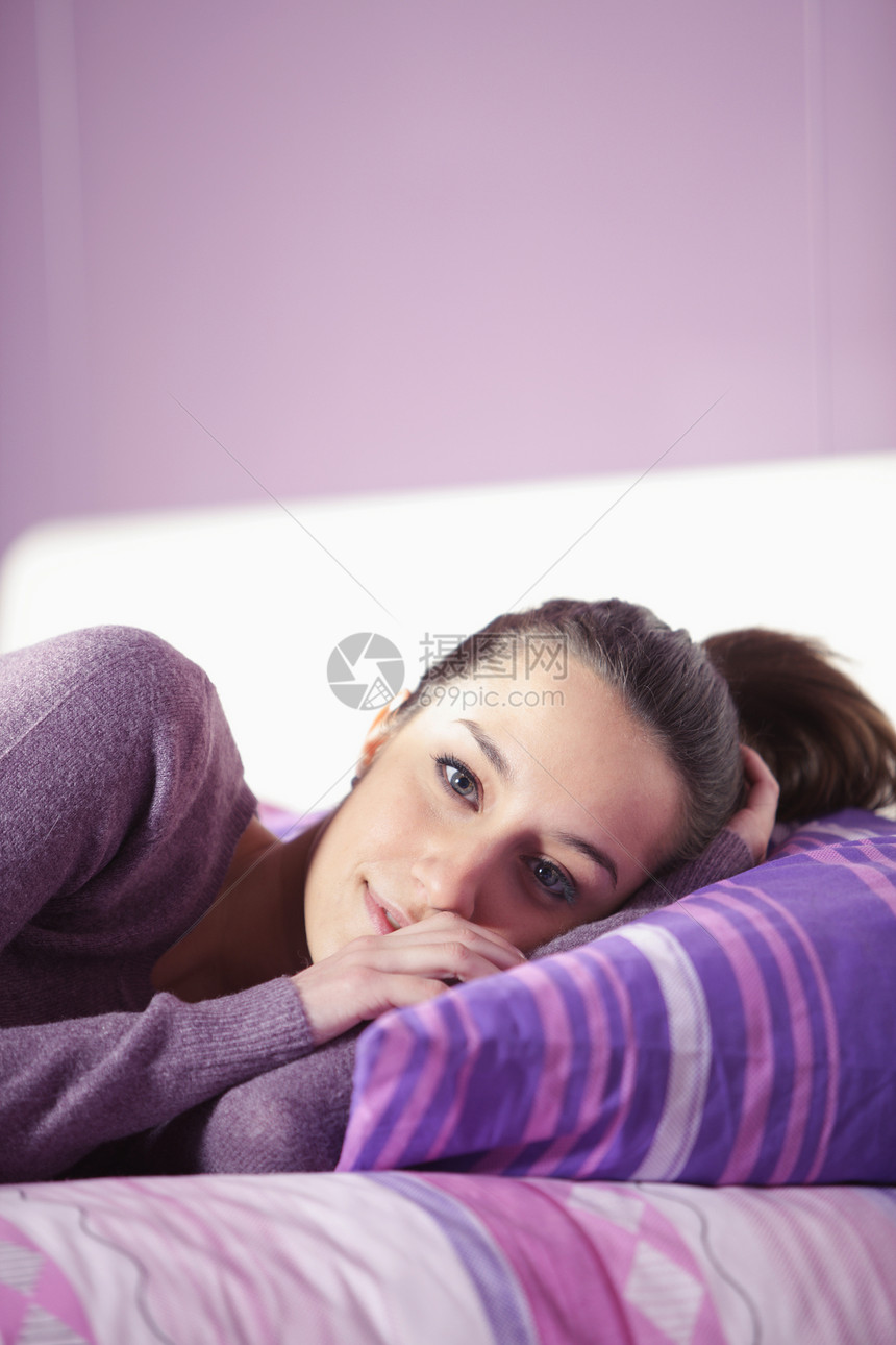 一名躺在床上的年轻女子的近身女性成人家居睡眠卧室模特房子时装图片