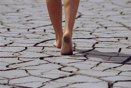 妇女赤脚徒足穿过破碎的大地 低片段高清图片
