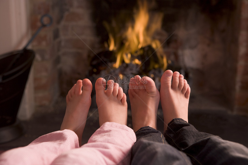 儿童脚在壁炉里变暖女孩脚趾木火季节女性家庭小男孩火焰男性孩子图片