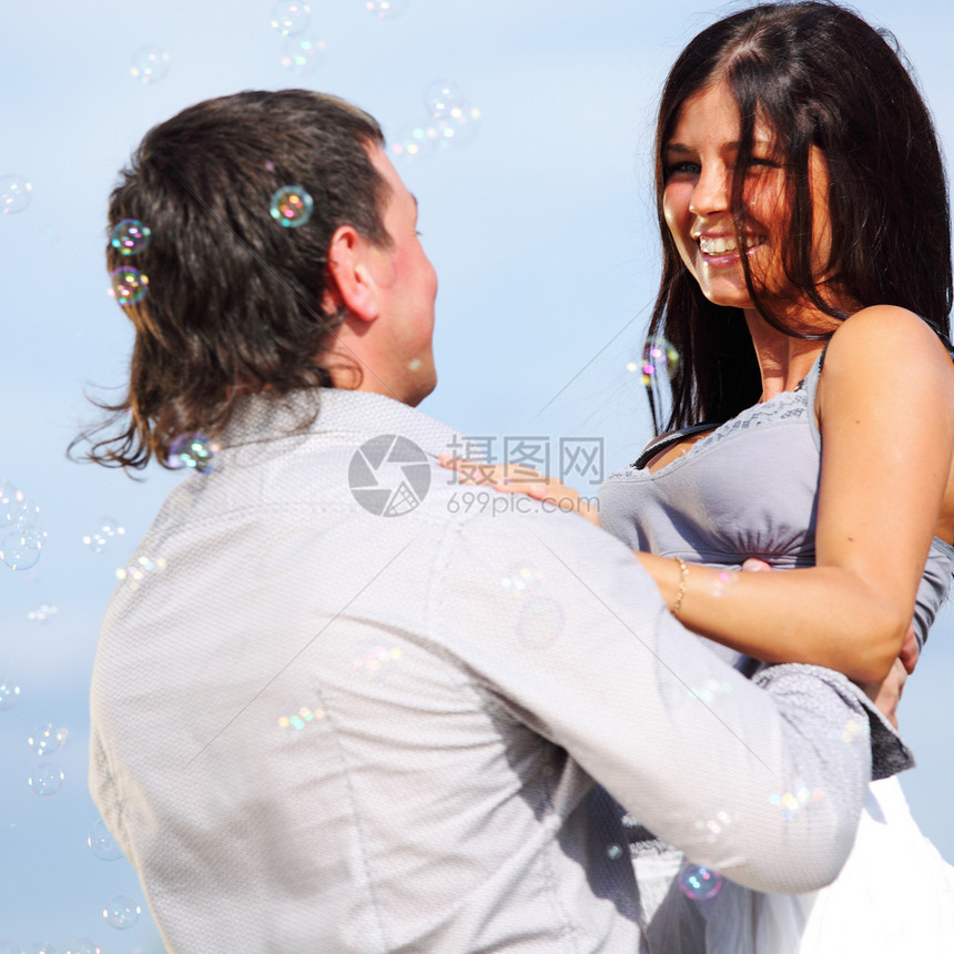 在天空中拥抱蜜月男人幸福男性妻子蓝色季节家庭成人太阳图片