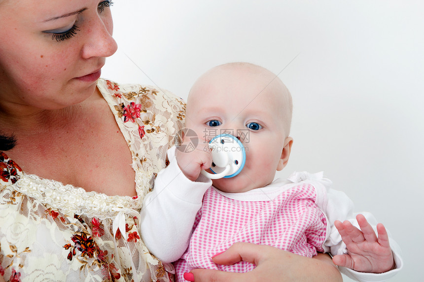 婴儿在母亲的怀抱中带有奶嘴女儿衣服妈妈女士家庭喜悦女性童年白色眼睛图片