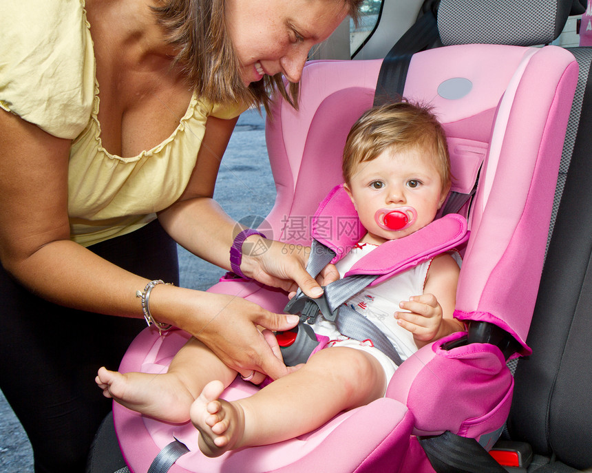 女人在汽车的婴儿座上绑着她儿子后座座位童年儿童家庭妈妈旅行安全母亲男生图片