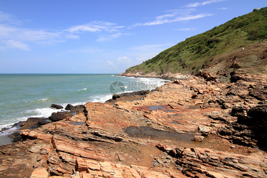 热带海滩上的石头异国海浪岩石情调旅行卵石冲浪处女地平线天空图片