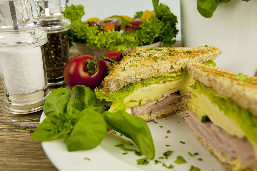 三明治加起司和火腿放在桌子上沙拉土豆面包俱乐部小吃午餐黄瓜饮食叶子食物图片
