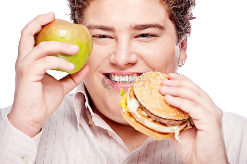 年轻胖子拿着苹果和汉堡包热量食欲水果晚餐美食饥饿脂肪男人重量男生图片