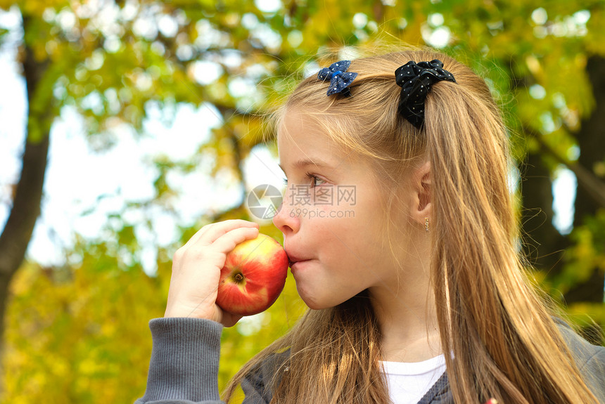 吃苹果的小女孩绿色女性公园小吃维生素红色食物女孩孩子快乐图片