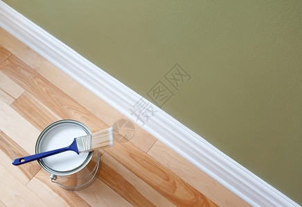 牙刷桶画笔和木制地板上的白漆罐子背景
