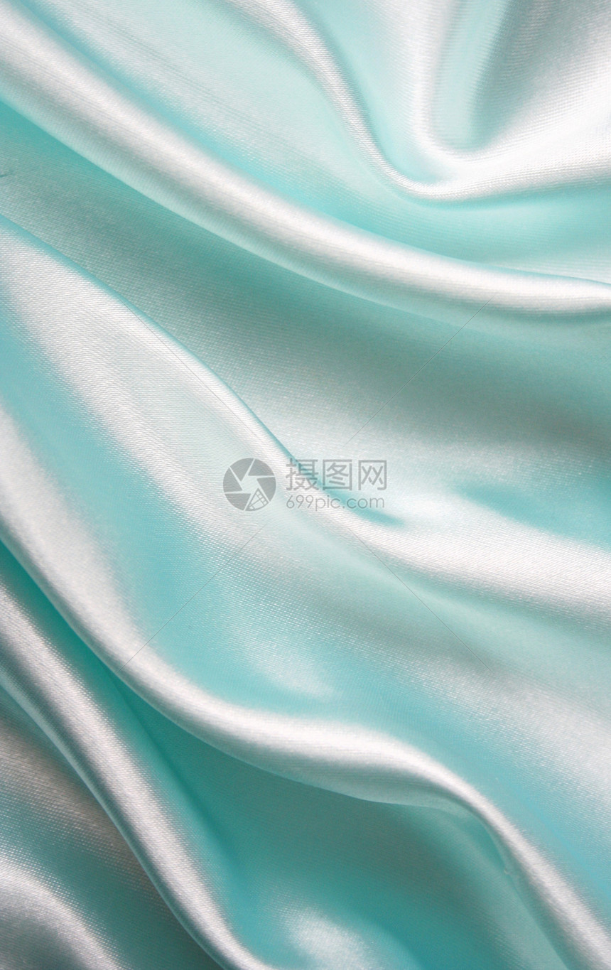 平滑优雅的蓝色丝绸作为背景海浪折痕织物材料曲线银色布料纺织品投标图片