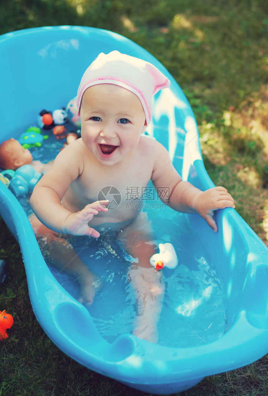迷人的婴儿在花园里洗澡图片